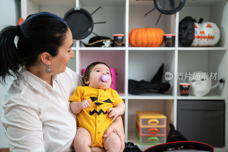 母亲和婴儿女孩的肖像穿杰克o' Lantern服装